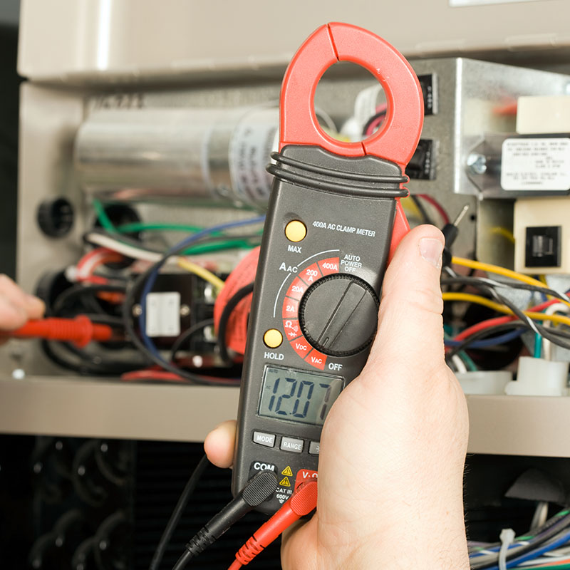 Repairman checks voltage on geothermal HVAC system